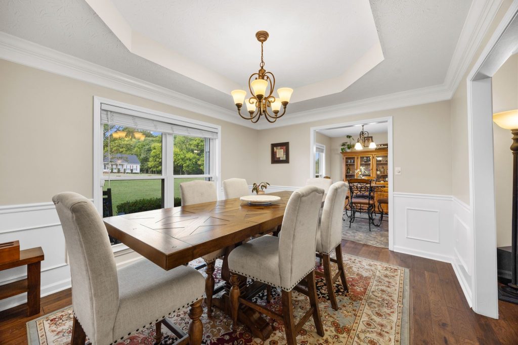 View listing details for the home pictured with a dining room featuring a tray ceiling, chandelier, and upholstered chairs.